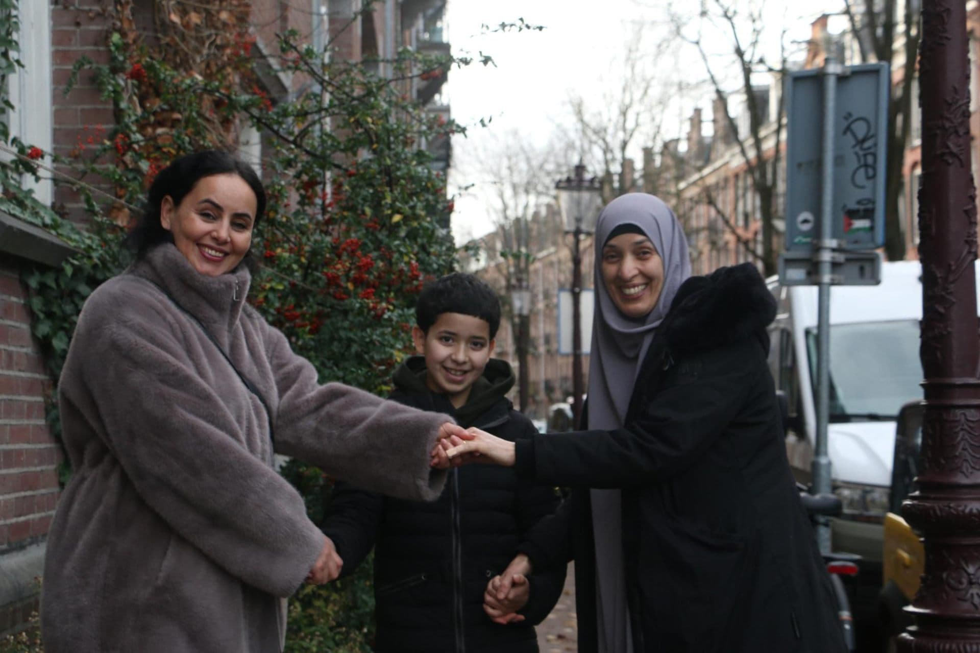 Two mothers and a child holding hands together in an Amsterdam street